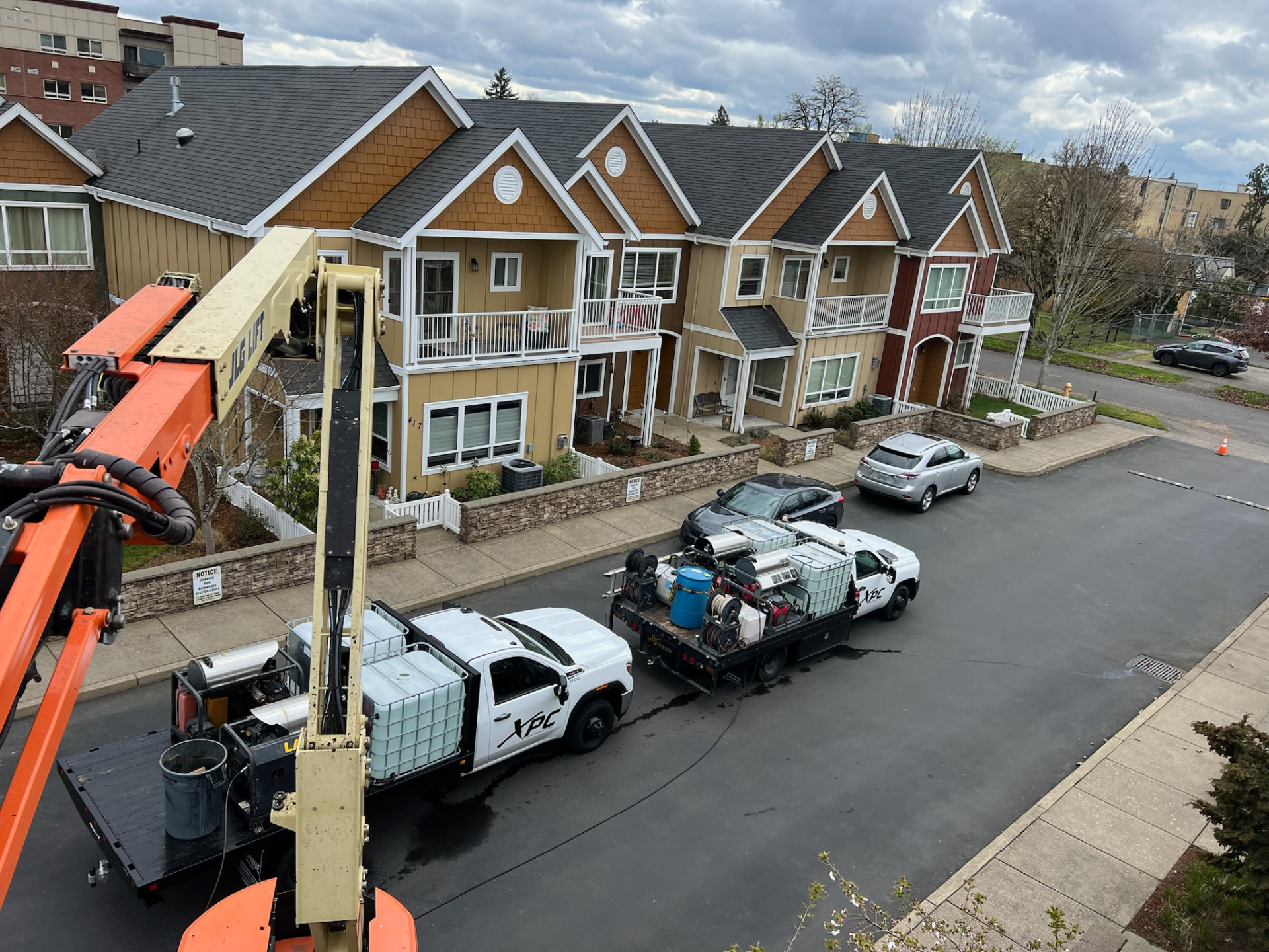Aerial view of XStream pressure washing rigs and boom lift at a townhouse complex